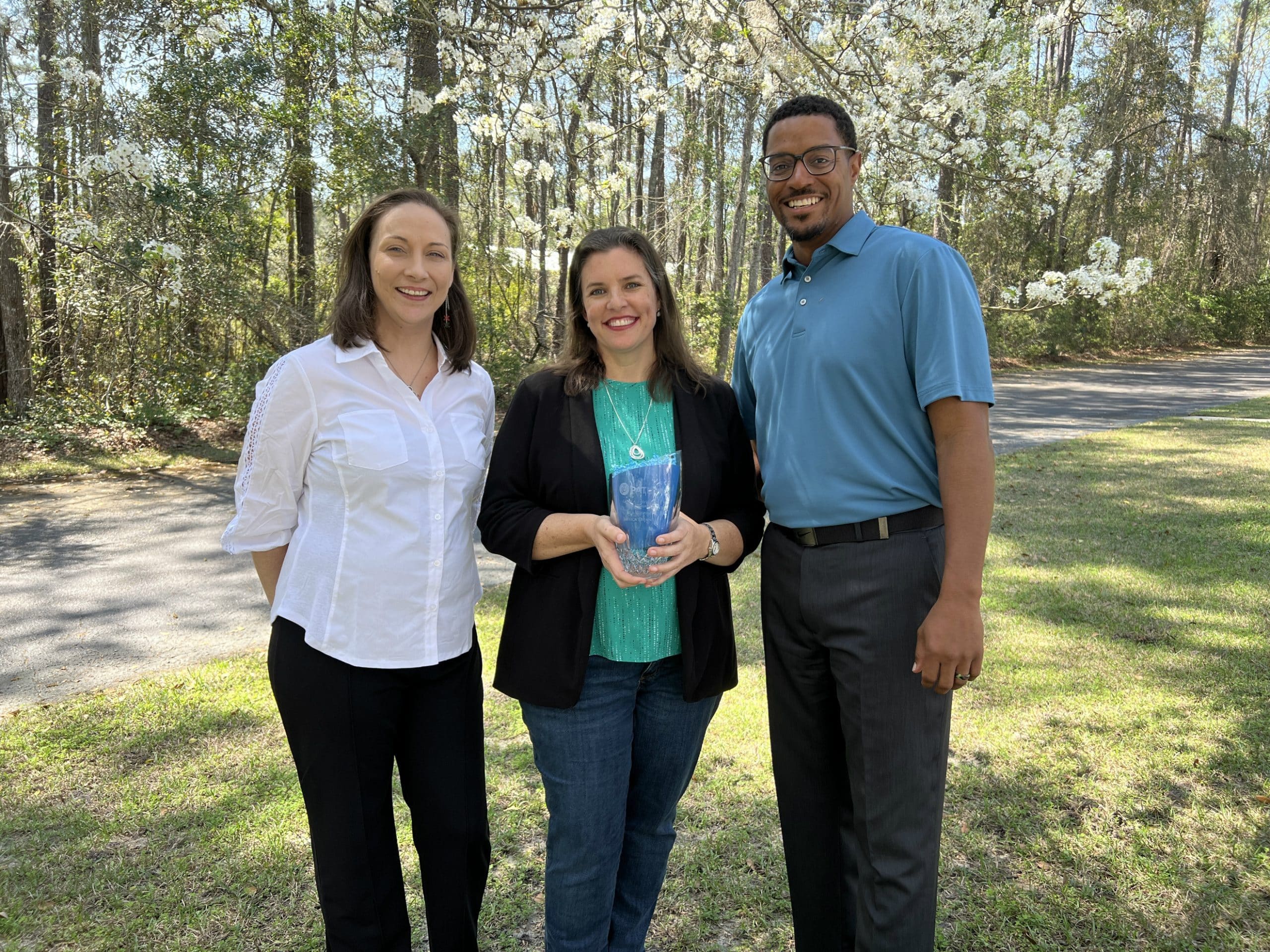 PATLive CEO Jackie Gonzalez presents the Glen A Davidson Award Winners Jessica Brennan and Duane Gilbert with their award outside the PATLive office in Tallahassee, Florida.
